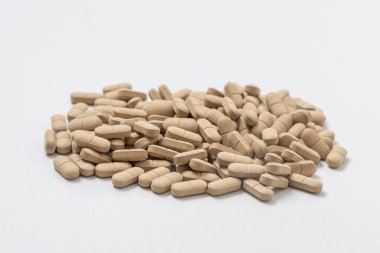 Oval kahverengi haplar beyaz bir masada beslenme takviyesi olarak kullanılıyor.