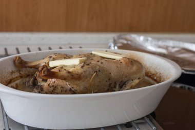Pişirme tepsisindeki ördek. Ördek fırında pişiyor. Koyu kahverengi kümes hayvanları.