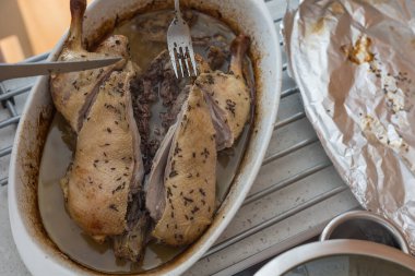 Pişirme tepsisindeki ördek. Ördek fırında pişiyor. Koyu kahverengi kümes hayvanları.