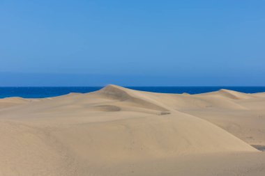 Maspaloma 'daki çöl manzarası ve kum tepeleri. Kum tepeleri ve deniz manzarası. Gran Kanarya Adası İspanya