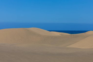 Maspaloma 'daki çöl manzarası ve kum tepeleri. Kum tepeleri ve deniz manzarası. Gran Kanarya Adası İspanya