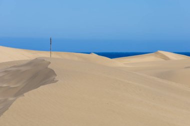 Maspaloma 'daki çöl manzarası ve kum tepeleri. Kum tepeleri ve deniz manzarası. Gran Kanarya Adası İspanya