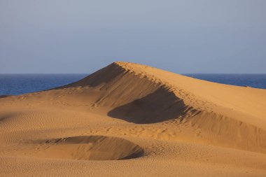 Maspaloma 'daki çöl manzarası ve kum tepeleri. Kum tepeleri ve deniz manzarası. Gran Kanarya Adası İspanya