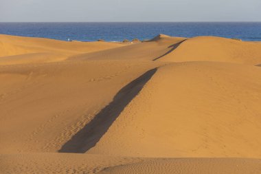 Maspaloma 'daki çöl manzarası ve kum tepeleri. Kum tepeleri ve deniz manzarası. Gran Kanarya Adası İspanya