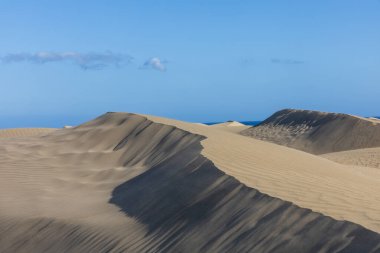 Maspaloma 'daki çöl manzarası ve kum tepeleri. Kum tepeleri ve deniz manzarası. Gran Kanarya Adası İspanya