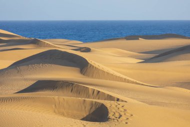 Maspaloma 'daki çöl manzarası ve kum tepeleri. Kum tepeleri ve deniz manzarası. Gran Kanarya Adası İspanya