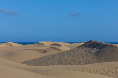 Maspaloma 'daki çöl manzarası ve kum tepeleri. Kum tepeleri ve deniz manzarası. Gran Kanarya Adası İspanya