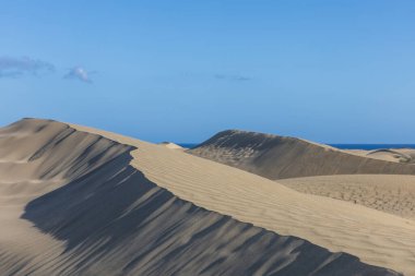 Maspaloma 'daki çöl manzarası ve kum tepeleri. Kum tepeleri ve deniz manzarası. Gran Kanarya Adası İspanya