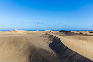 Maspaloma 'daki çöl manzarası ve kum tepeleri. Kum tepeleri ve deniz manzarası. Gran Kanarya Adası İspanya