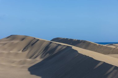 Maspaloma 'daki çöl manzarası ve kum tepeleri. Kum tepeleri ve deniz manzarası. Gran Kanarya Adası İspanya