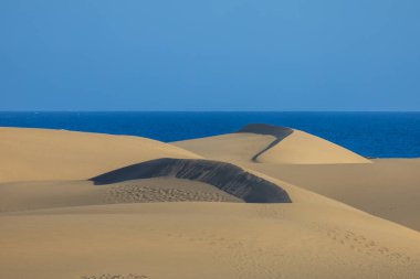 Maspaloma 'daki çöl manzarası ve kum tepeleri. Kum tepeleri ve deniz manzarası. Gran Kanarya Adası İspanya