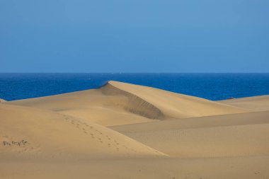 Maspaloma 'daki çöl manzarası ve kum tepeleri. Kum tepeleri ve deniz manzarası. Gran Kanarya Adası İspanya