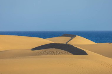 Maspaloma 'daki çöl manzarası ve kum tepeleri. Kum tepeleri ve deniz manzarası. Gran Kanarya Adası İspanya