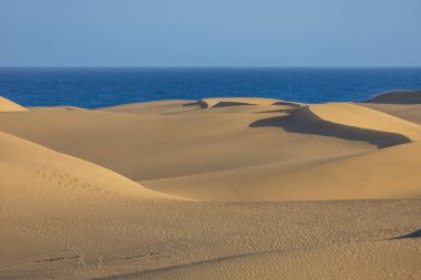 Maspaloma 'daki çöl manzarası ve kum tepeleri. Kum tepeleri ve deniz manzarası. Gran Kanarya Adası İspanya