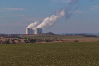 Çek Cumhuriyeti, Avrupa 'daki Dukovany Nükleer Santrali. Duman soğutma kuleleri. Gökyüzünde bulutlar var. Arka planda İskoçya 'nın doğası....