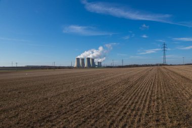 Çek Cumhuriyeti, Avrupa 'daki Dukovany Nükleer Santrali. Duman soğutma kuleleri. Gökyüzünde bulutlar var. Arka planda İskoçya 'nın doğası....