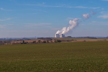 Çek Cumhuriyeti, Avrupa 'daki Dukovany Nükleer Santrali. Duman soğutma kuleleri. Gökyüzünde bulutlar var. Arka planda İskoçya 'nın doğası....
