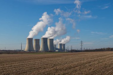 Çek Cumhuriyeti, Avrupa 'daki Dukovany Nükleer Santrali. Duman soğutma kuleleri. Gökyüzünde bulutlar var. Arka planda İskoçya 'nın doğası....