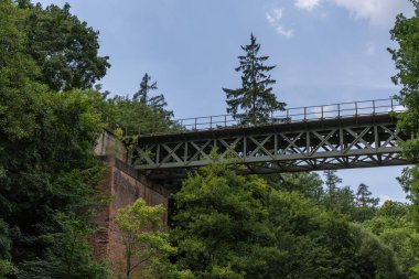 Vadinin üzerindeki demiryolu köprüsü. Etrafında ağaçlar ve çalılar yetişiyor.