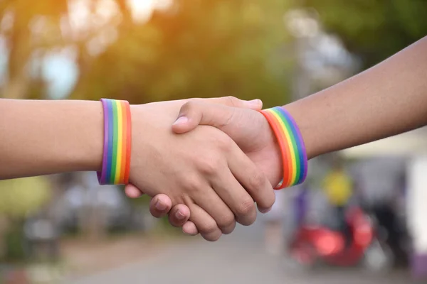 代わりのセックスで人権を尊重するために いくつかの宗教で同性愛者を罰するのを止めるために 若いアジアのゲイの手に身を包んだレインボーリストバンド — ストック写真