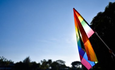 Gökkuşağı bayrağı, LGBT simbol, açık mavi arka plan, yumuşak ve seçici odak, LGBT konsepti gurur ayı, Haziran, dünya çapında, kopyalama alanı.