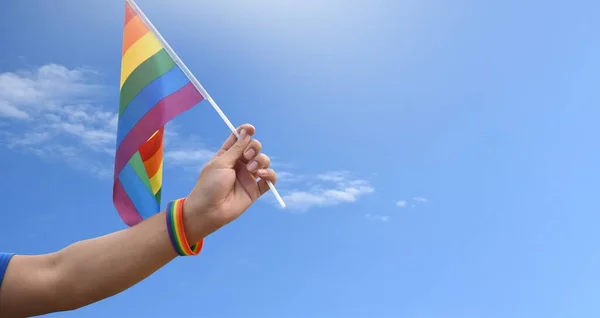 手に持っている虹の旗とリストバンド 柔らかく選択的な焦点 Lgbtq 性別のお祝いのための概念と世界中の誇りの月に人権を尊重するすべての人々を呼び出します — ストック写真