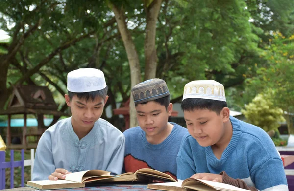 Молодые Азиаты Мусульмане Исламские Мальчики Сидят Вместе Школьном Парке Читать — стоковое фото