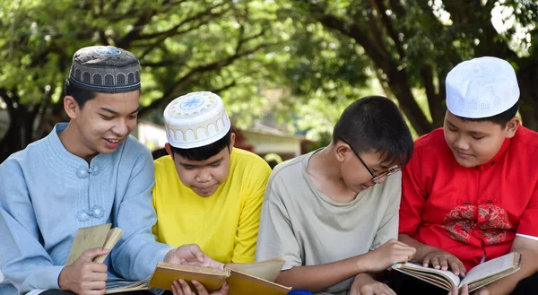 Grupa Muzułmańskich Chłopców Siedzi Razem Pod Drzewem Parku Szkolnym Czytają — Zdjęcie stockowe