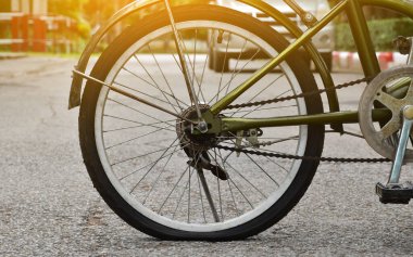 Düz ve yolun kenarındaki kaldırıma park edilmiş bir bisikletin arka tekerleği..