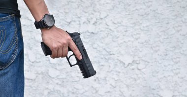 9 mm 'lik izole bir tabanca. Kesme yolları olan bir nişancının sağ elinde duruyor..