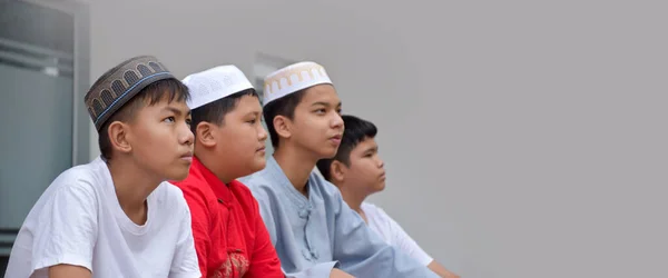 亚洲穆斯林或伊斯兰男孩与穆斯林男孩连续坐在一起祈祷或从事宗教活动 活动重点柔软且有选择性 — 图库照片