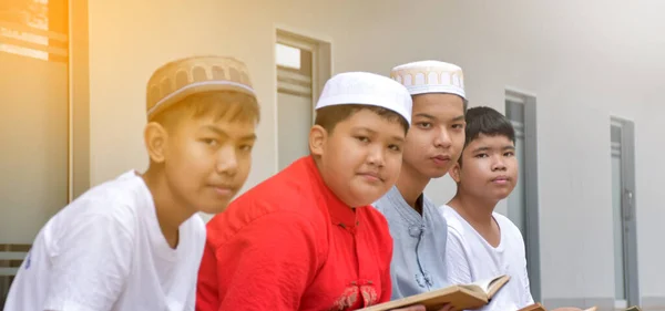 亚洲穆斯林或伊斯兰男孩与穆斯林男孩连续坐在一起祈祷或从事宗教活动 活动重点柔软且有选择性 — 图库照片