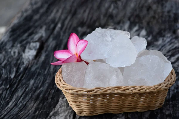 stock image Soft focus of Alum cubes and plumeria flower on small wicker basket, blurred background, concept for herb, bodycare, skincare, waterclear, spa, treatment, disease protection and protect armpit smell.