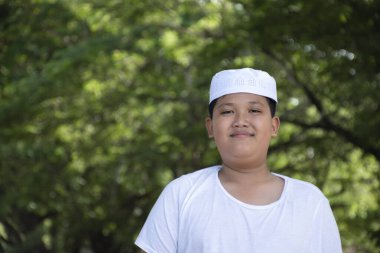 Portrait of asian muslim or islamic boy in white suit and hat, soft and selective focus.
