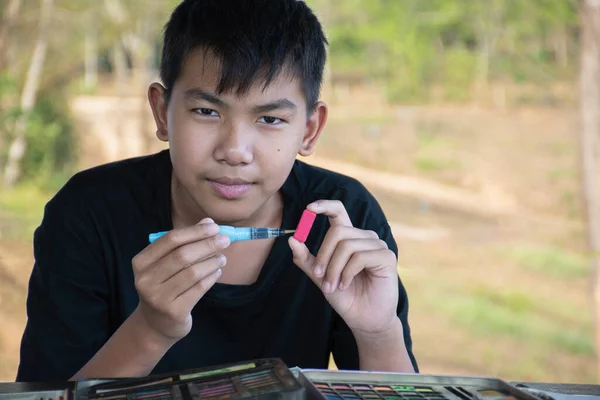 Asiatisk Pojke Håller Pensel Och Fast Ljus Röd Fyrkantig Bar — Stockfoto
