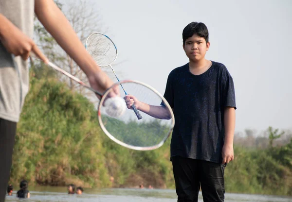 Asyalı Oğlanlar Hafta Sonu Tatillerinde Nehir Kıyısında Durup Oynarken Badminton — Stok fotoğraf
