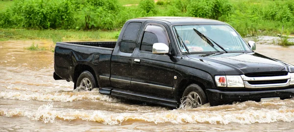 stock image Muddy rain from a heavy rainy season flooded main roads connecting the district, making it difficult for cars to pass through and causing engine failures, in motion, car insurance concept.