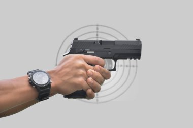 Atış poligonunun önünde 9 mm 'lik tabanca tutan silahlı bir adam..