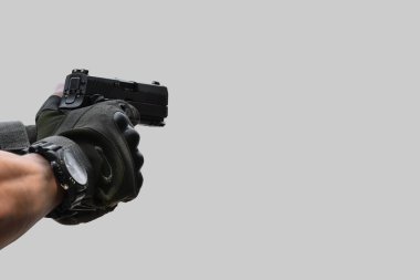 Atış poligonunun önünde 9 mm 'lik tabanca tutan silahlı bir adam..