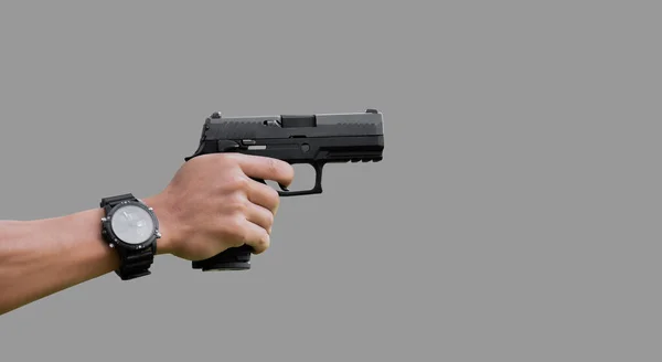 持枪男子手持9毫米手枪在射击目标范围前 有选择地瞄准手 背景模糊 — 图库照片