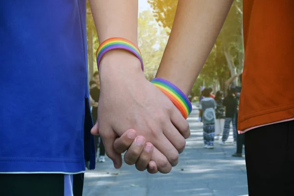 公園の通りを歩きながら虹色のリストバンドと握手をする若者のグループの前でアジアのゲイの手のクローズアップビュー Lgbtの人々のための概念彼らの愛を提示 — ストック写真