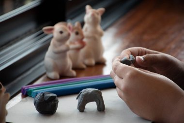 Otistik bir çocuk, ebeveynler tarafından normal çocuklardan daha yavaş beyin gelişimine sahip olan oğullarında çeşitli yönler geliştirmek için evde hazırlanmış farklı renkli plastikler üretiyor..