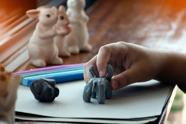 stock image An autistic boy molding different shapes of colored plasticine prepared by parents at home in order to develop various aspects in their son which has slower brain development than normal children.