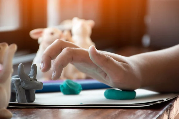stock image An autistic boy molding different shapes of colored plasticine prepared by parents at home in order to develop various aspects in their son which has slower brain development than normal children.