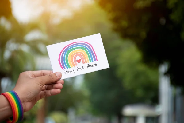 快乐骄傲月 卡片手握彩虹腕带 这是在骄傲月邀请所有人参加全球Lgbtq 活动的理念 — 图库照片