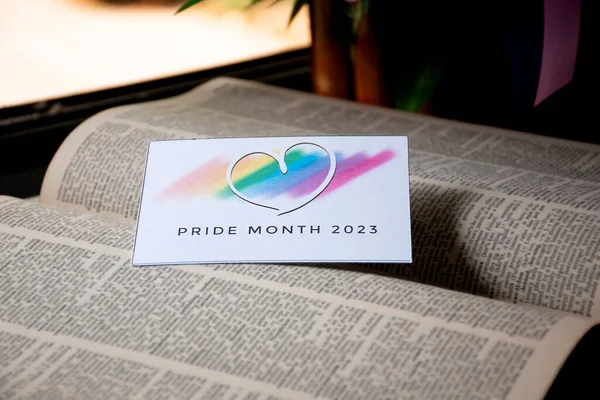 在翻开的旧书上画上彩虹色的心像 用2023年的卡片 模糊的背景 邀请所有人在骄傲月庆祝Lgbtq 活动的理念 — 图库照片
