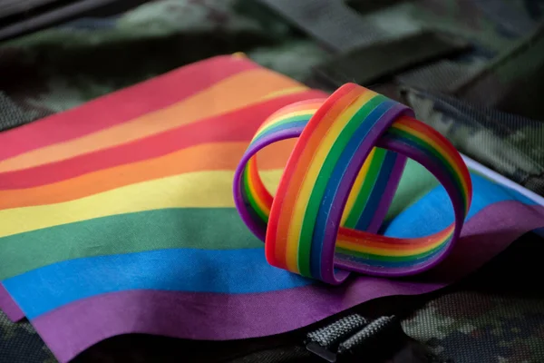 彩虹旗帜和彩虹腕带的伪装背景 概念庆祝男女同性恋 双性恋和变性者自豪月在世界各地 软和有选择地关注腕带 — 图库照片