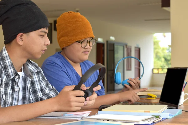 一群亚洲男孩坐在一起做他们学校的项目工作 他们使用笔记本电脑在网站上搜索重要信息 互相咨询 软弱无力 有选择地集中注意力 — 图库照片