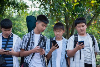 Okuldan sonra birlikte eve yürürken cep telefonu kullanan Asyalı genç çocuklar, gençlerin yaşam tarzı, çocukluk ve gençlerin zaman geçirme konsepti..