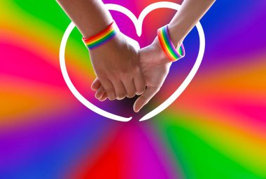 Bulanık LGBTQ + bayrak geçmişi olan gökkuşağı bileklikleri takan eşcinsel çiftlerin yakın çekim elleri, insanların aynı cinsiyette sevgiyi gösterme konsepti ve Gurur Ayı etkinliklerinin kutlaması.
